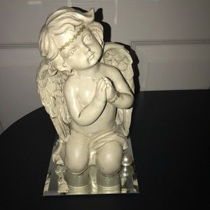 Gold praying angle sitting on glass mirror